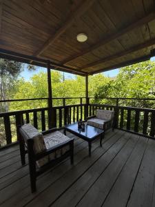 a porch with two chairs and a table on a deck at Kybele Nature Life in Edremit