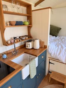 a kitchen with a sink and a bed in a room at Shepherds Hut in St Austell +19 photos