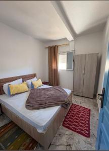 a bedroom with a bed and a red rug at dar fatma matmata in Matmata