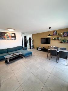 a living room with a blue couch and a table at Dream house in Eilat