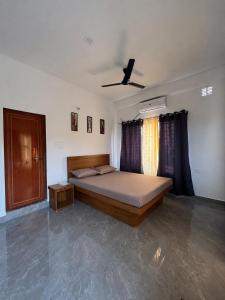 a bedroom with a bed and a ceiling fan at KwaChen Stays in Panchanai