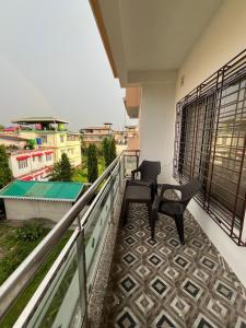 a balcony with two chairs and a view at KwaChen Stays in Panchanai +1 photo