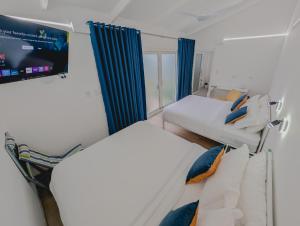 ein kleines Zimmer mit zwei Betten und einem Fernseher in der Unterkunft T Loft in Playa Hermosa + 38 Fotos