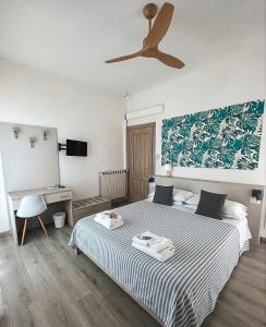 a bedroom with a bed and a ceiling fan at Hotel Maremola in Pietra Ligure