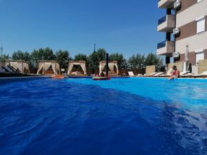 a large swimming pool with blue water in a building at Harmony Srebrno jezero in Veliko Gradište +14 photos
