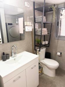 a bathroom with a sink and a toilet and a mirror at Dream house in Eilat +20 photos