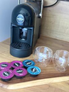 a coffee maker with buttons on a table with glasses at Peaceful haven in Liepāja +13 photos