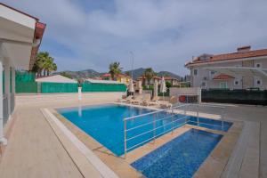 a swimming pool with chairs and a house at villa hazar in Ortaca