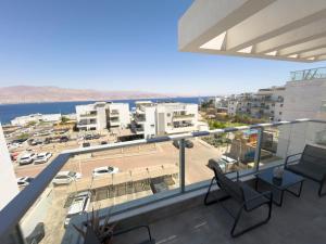 a balcony with chairs and a view of a parking lot at Dream house in Eilat