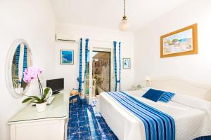 a bedroom with a bed and a desk with a computer at Hotel Villa Delle Palme in Positano in Positano