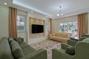 a living room with couches and a flat screen tv at villa hazar in Ortaca