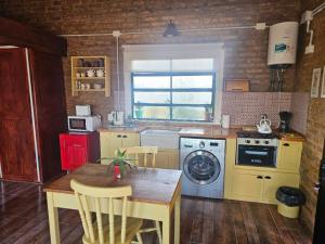 a kitchen with yellow appliances and a table with chairs at Don Vito Casa de Huespedes in Cucullú
