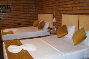 two beds sitting in a room with at Elephant Arcade Yala in Tissamaharama