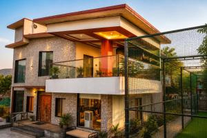 a house with a balcony with glass doors at Royal Heritage Lonavla - 7BHK with Turf in Lonavala