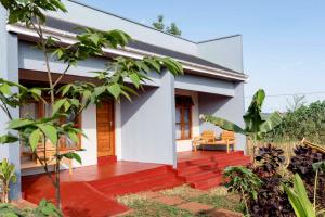 a white house with a red deck at Marera Eco Lodge in Karatu