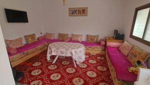 a living room with a purple couch and a table at Villa Bingo & Piscine in El Jadida