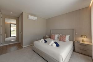 a bedroom with a large white bed and a window at Quinta da Lagoeira in Caldas da Rainha