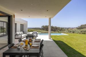 a patio with a table and chairs and a pool at Quinta da Lagoeira in Caldas da Rainha