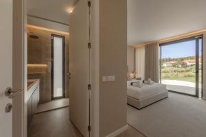 a living room with a white couch and a large window at Quinta da Lagoeira in Caldas da Rainha +37 photos