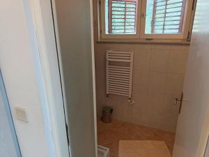 a bathroom with a window and a radiator in a room at Pine Breeze in Punat +8 photos