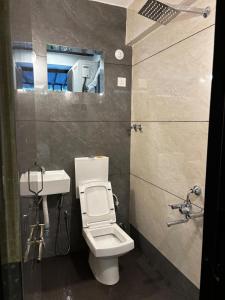 a bathroom with a toilet and a sink at 1Rk Karwar downtown Studio in Kārwār
