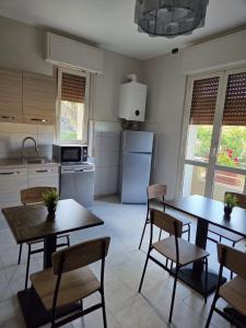 a kitchen with two tables and chairs and a refrigerator at B & B L'Altropianeta in Spoltore