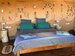 a bedroom with a large bed with green pillows at Marudzi Sunset Lodge in Umtali