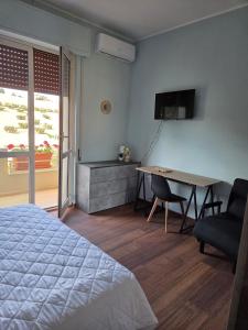 a bedroom with a bed and a desk and a table at B & B L'Altropianeta in Spoltore