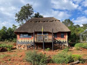 a small hut with a thatched roof in a field at Marudzi Sunset Lodge in Umtali