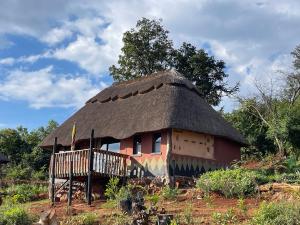 a small hut with a thatched roof on a hill at Marudzi Sunset Lodge in Umtali