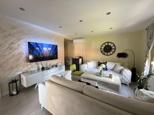 a living room with a couch and a tv on a wall at Villa Magnifica in Mostar