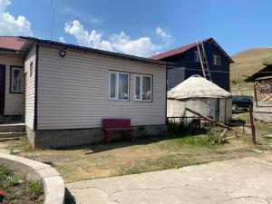 a small house with a yurt in front of it at Guest house Aibek in Kurmenty