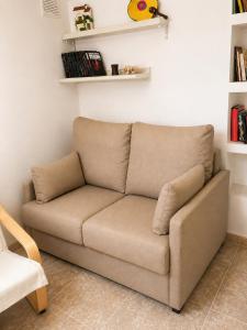 a brown couch in a room with shelves at Cal Folquer in Alentorn