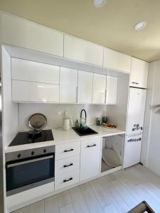 a white kitchen with white cabinets and a sink at Villa Magnifica in Mostar
