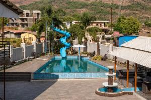 a swimming pool with a blue slide in a resort at Royal Heritage Lonavla - 7BHK with Turf in Lonavala