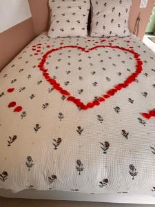 a bed with a heart drawn on it at La petite maison de Celestine in Plonéour-Lanvern +20 photos