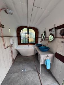 a bathroom with a tub and two sinks and a bath tub at The Carriage Lorry at Tilleys Glamping in Birchington +5 photos