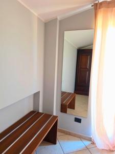 a room with a wooden bench and a mirror at EffeVi - Bed and Books in Piaggine