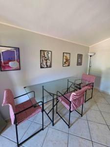 a dining room with a glass table and two chairs at EffeVi - Bed and Books in Piaggine +1 photo