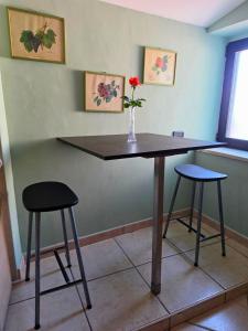 a table with two stools and a vase of flowers on it at EffeVi - Bed and Books in Piaggine