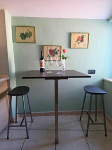 a table with two chairs and two wine glasses at EffeVi - Bed and Books in Piaggine