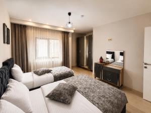 a hotel room with two beds and a mirror at NORA SUİTE in Trabzon