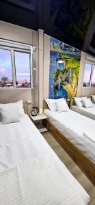 a room with two beds and a painting on the wall at Cheap Hotel in Center in Tashkent
