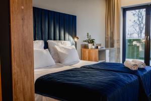 ein Schlafzimmer mit einem großen Bett und einer blauen Decke in der Unterkunft Natural Hotel przy plaży-Ostróda-basen na III kondygnacji in Ostróda + 43 Fotos