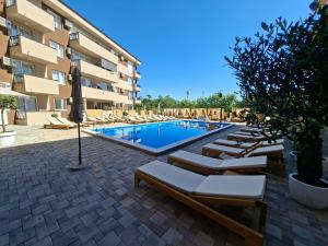 ein Schwimmbad mit Liegestühlen und ein Hotel in der Unterkunft Silver 1 & SPA in Veliko Gradište