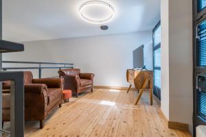 a living room with leather furniture and a tv at Effealatapartments - EdenLoft in Senigallia