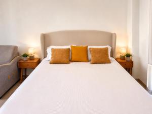 a bedroom with a large white bed with two lamps at Depandance Eleonora in Oristano