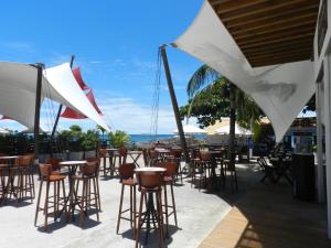 un bar con sillas, mesas y sombrillas en Apartamento Oceano Atlantico, en Salvador