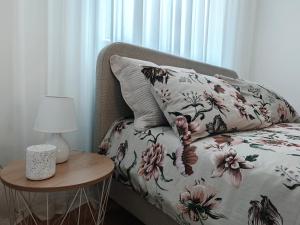 a bed with a pillow and a table with a lamp at Stella Verde in Vršac