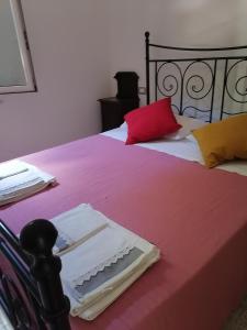 a bedroom with two beds with red and yellow pillows at La Raccolta in Scheggino